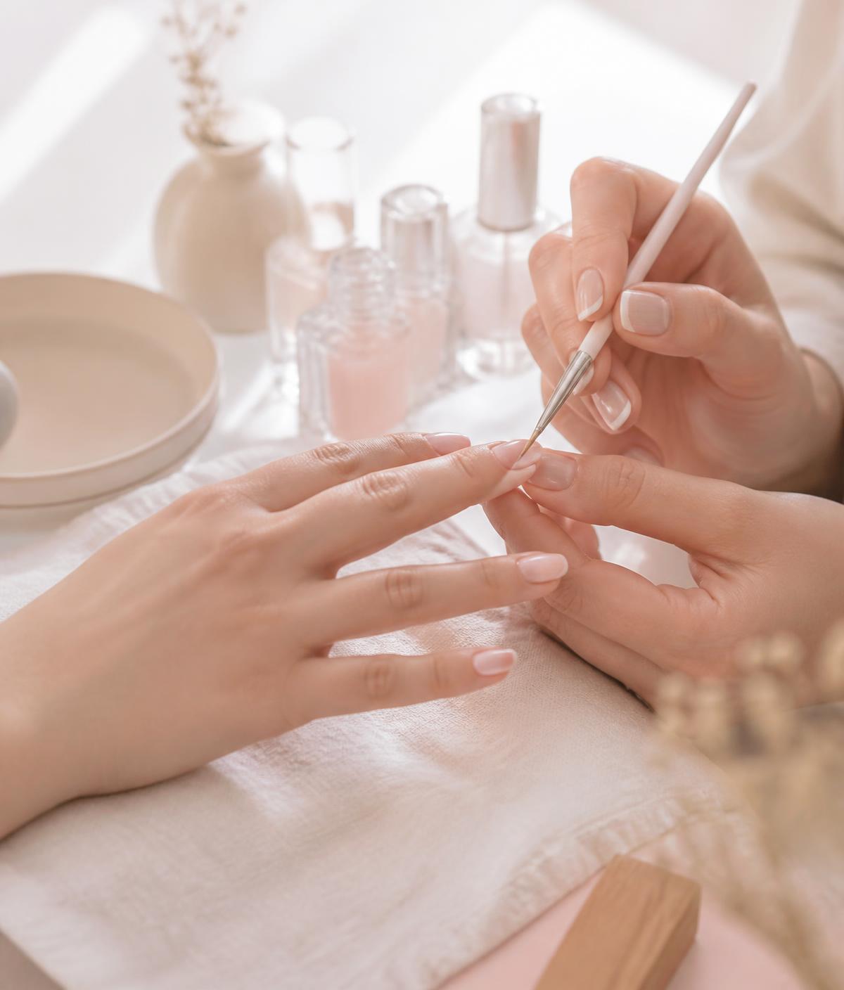 Nail technician applying fine detail with a nail art brush